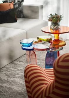 a living room filled with furniture and a glass table topped with a potted plant