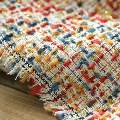 a close up view of a multicolored rug with fringes and beads on it