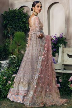 Pakistani Wedding Dress in Lehenga Frock Style is a stunning attire that has the perfect balance of elegance and royalty. This magnificent Pakistani Bridal Dress is beautifully embellished with pearls and sequins. Graceful embroidery and designs make this perfectly stitched attire your foremost priority for the big day. Frock: Pakistani Bridal Frock in the alluring pink shade having premium quality net fabric is gracefully embellished with sequins. Floral designs, embroidery, and gota details ma Bollywood Style Organza Wedding Dress With Dabka Work, Organza Wedding Dress With Dabka Work, Traditional Drape Gown With Pearl Embroidery For Wedding, Bollywood Style Long Embellished Gown, Traditional Drape Wedding Gown With Pearl Embroidery, Semi-stitched Wedding Dress With Pearl Embroidery, Traditional Drape Pearl Embroidered Wedding Gown, Organza Wedding Dress With Dabka Work For Reception, Bollywood Style Organza Gown For Wedding