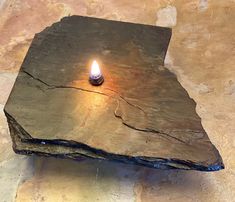 a candle is lit on a piece of wood