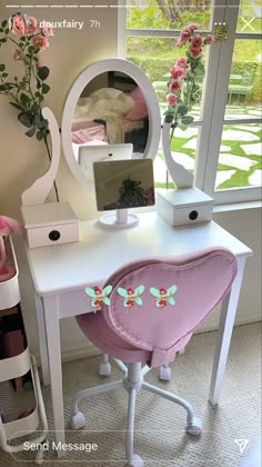 a white desk with a mirror and flowers on it