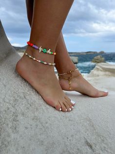 Add a touch of unique style to your summer wardrobe with these stunning handmade ankle bracelets! The first one boasts a colorful array of beads in different shapes, accented by white coral beads, gold metal parts, and a round evil eye charm in green color for added protection and good luck. The second bracelet features luminous white freshwater pearls, alongside vibrant colorful beads and gold metal parts, for an elegant yet playful look. Both bracelets are fully adjustable to fit any ankle siz Colorful Beaded Bracelets For Summer Beach, Colorful Beads Bracelet For Summer Beach, Colorful Beaded Bracelets For Beach And Summer, Colorful Beaded Anklets For Beach Vacation, Colorful Beaded Bracelet For Beach In Summer, Colorful Beads Anklet For Beach Season Vacation, Colorful Beaded Anklets For Vacation And Beach Season, Multicolor Tiny Beads Bracelets For Beach Season, Multicolor Tiny Beads Bracelet For Beach Season