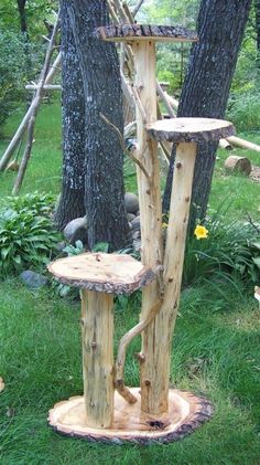 a tree stand made out of logs in the grass