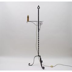 a black and white floor lamp with a candle on the top, next to it's holder