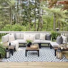 an outdoor living area with couches, tables and potted plants on the deck