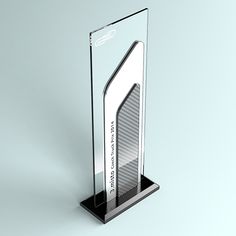 a glass trophy with the shape of a skyscraper on it's base is shown in front of a gray background