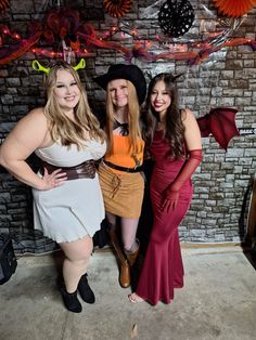 three women dressed up in costumes posing for the camera