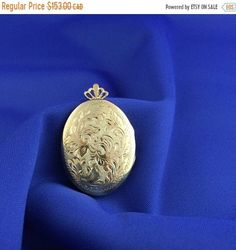 This beautiful 18 kt gold plated on sterling silver Vintage locket is hand engraved in Canada. It is brand new and has never been worn before. The locket measures 43 m or 1 11/16 inches long and 28 mm or 1 1/8 inches wide including the bail. Gold Brass Locket Necklace For Formal Occasions, Gold Brass Locket Necklace For Formal Events, Formal Gold Brass Locket Necklace, Ornate Engraved Locket Necklace For Formal Occasions, Ornate Engraved Locket Necklace For Formal Events, Ornate Gold Locket Necklace Gift, Gold Etched Locket Necklace For Wedding, Ornate Gold Locket Necklace For Formal Occasions, Hallmarked Pendant Locket Necklace For Wedding