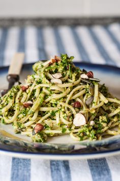 pasta with broccoli and almonds on a blue and white striped tablecloth