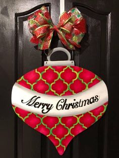 a christmas ornament hanging on a door with a bow and ribbon around it