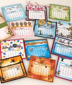 several calendars with different designs and colors are shown on a table top in front of a white background