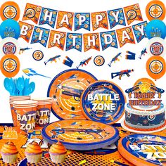 an orange and blue birthday party set up with plates, cups, napkins and decorations