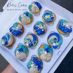 blue and white cupcakes are in a box