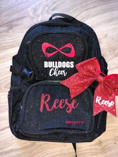 two backpacks with red bows on them sitting on the floor next to each other