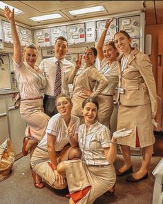 a group of women dressed in uniforms posing for a photo with their hands up and smiling at the camera