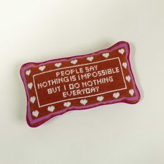 a red and white pillow that says people say nothing is impossible but i do nothing everyday