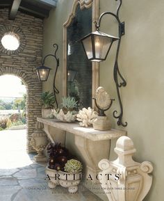 an entry way with a stone wall and planters on the ledge, along with a large mirror