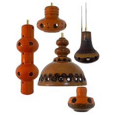 an assortment of hanging lights made from clay and wood with holes in the top, on white background