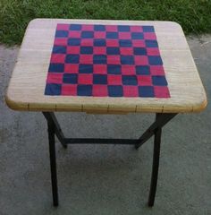 a wooden table with a red and blue checkerboard design on it's top