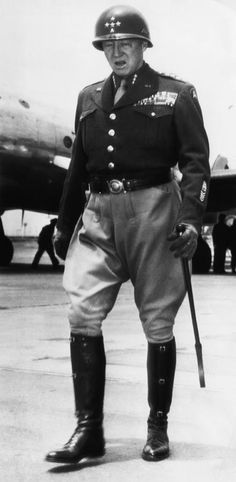 a man in uniform standing next to an airplane