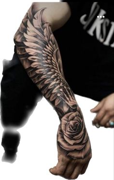 a man's arm with a rose and wings tattoo on his arm, in black and white