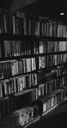 black and white photograph of bookshelves in a library