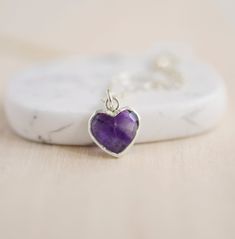 Give yourself some love or show your love for that special someone in your life with this heart necklace!Amethyst is believed to carry the energies of passion, creativity, and spirituality. It's also said to assist with temperance and sobriety, as well as inflammation.This necklace is handcrafted with a purple Amethyst faceted heart pendant. Each stone is natural and therefore contains natural inclusions or crystal formations. They are edged in 24k gold or silver electroplate. STONE SIZE: averag Amethyst Birthstone Heart Pendant Jewelry, Heart Cut Amethyst Jewelry For Gifts, Spiritual Gemstone Charm Necklace As Gift, Spiritual Adjustable Birthstone Necklace As A Gift, Adjustable Spiritual Birthstone Necklace As A Gift, Heart Pendant Amethyst Jewelry As Gift, Heart Shaped Amethyst Pendant Jewelry As Gift, Amethyst Heart Pendant Jewelry As Gift, Sterling Silver Crystal Necklace For Valentine's Day Gift