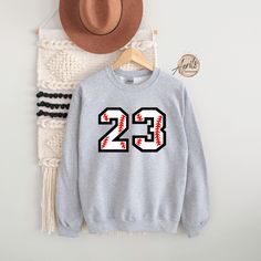 Custom Baseball Number Sweatshirt or Hoodie, Baseball Sweatshirt, Baseball Hoodie, Personalized Hoodie, Custom Sweatshirt, Softball Hoodie CAUTION: For security reasons, there is no rope in the throat area for youth hoodie. Hello!! Dear Customer, We're here to give you best Custom Sport  sweatshirt, hoodie and crewneck options for you. We want to make everyone smile with our cute , stylish and trendy graphic T-shirts. We can assured you this shirt will be perfect Custom Sport sweatshirt, hoodie Varsity Crew Neck Sports Hoodie, Crew Neck Hoodie For Sports Events, Gray Varsity Hoodie Sweatshirt, Sports Fan Apparel Hoodie Sweatshirt, Long Sleeve Sweatshirt With Ribbed Cuffs For Sports, Ribbed Cuffs Long Sleeve Sweatshirt For Sports, Sportswear Hoodie Sweatshirt For Sports Events, Sporty Winter Sweatshirt For Sports Events, Team-colored Long Sleeve Sweatshirt For Winter