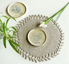 two plates with designs on them sitting next to a plant