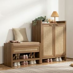 a wooden cabinet with shoes on it and a lamp in the corner next to it