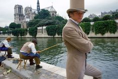 a man in a top hat is fishing on the water