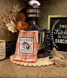 a kitchen counter topped with a mixer and a bag filled with pumpkins on top of it