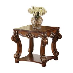 a wooden table topped with a glass vase filled with white flowers on top of it