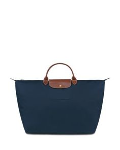 With a packable design and roomy interior, Longchamp's leather-trimmed travel bag is a jet-setter's necessity for work or play. Navy Blue Longchamp, Longchamp Le Pliage Pouch, Longchamp Le Pliage Navy, Longchamp Le Pliage Pouch With Handle, Longchamp Leather, Small Travel Bag, Swimsuit Cover Up Dress, Bridal Boots, Red Summer Dresses