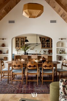 the dining room table is surrounded by wooden chairs and upholstered armrests