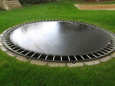 a large metal object sitting on top of a lush green field