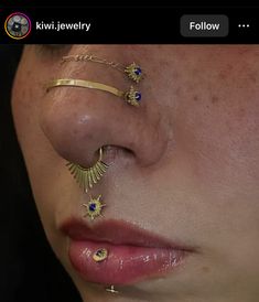 a close up of a person with piercings on her nose and nose ring,