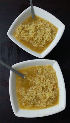 two white bowls filled with soup on top of a black table next to each other