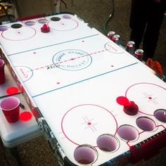 an air hockey table with red cups on it