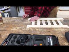 a man is working on some wood with his toolbox and other tools in front of him