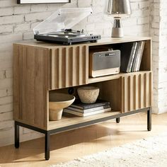 a record player is sitting on top of a wooden entertainment center with books and records