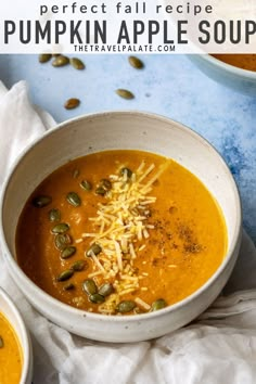 two bowls filled with pumpkin soup and topped with shredded cheese