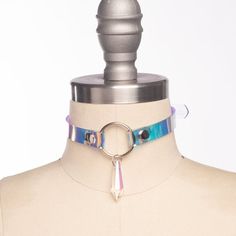 Classic choker collar in iridescent, holographic vinyl layered over PVC. An aurora borealis chandelier crystal point adorns the center o-ring. Fit is adjustable with buckle. Holes are reinforced with grommets.This is the mini version - slightly slimmer with a smaller crystal for a more delicate look!Collar is 1/2" wide, with a 1" crystal point.SMALL/MEDIUM (11-13")MEDIUM/LARGE (13-15")LARGE/X-LARGE (15-17")Custom sizing available.  All pieces are MADE TO ORDER, standard sizes S/M-L/XL.  If your Pink Choker, Harness Bra, Chandelier Crystal, Holographic Vinyl, Crystal Choker, Choker Collar, Crystal Points, Aurora Borealis, Crystal Chandelier