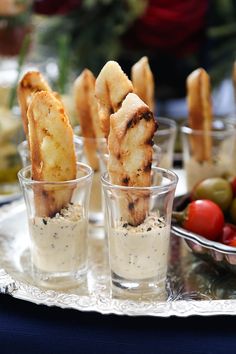 small cups filled with food on top of a silver tray