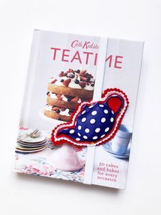 a cookbook with an image of a cake on the cover and a red white and blue pin