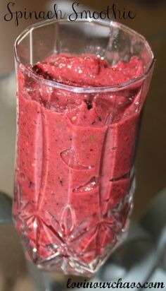 a glass filled with red liquid on top of a table