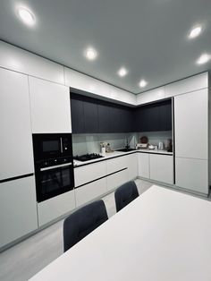 a white table and chairs in a room with lights on the ceiling above it,