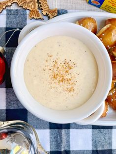 there is a bowl of soup and some pretzels on the table next to it