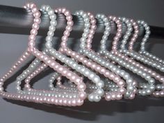 a bunch of beads that are sitting on a table next to a black object with white and pink beads