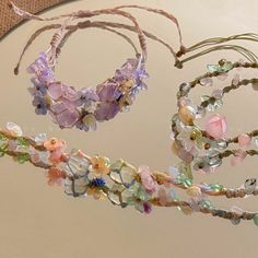 three bracelets with flowers on them are hanging from a string in front of a mirror